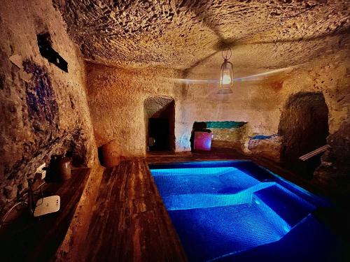 a swimming pool in a cave with blue lights at Dreamy space with caved pool in Ħofret ir-Rizz