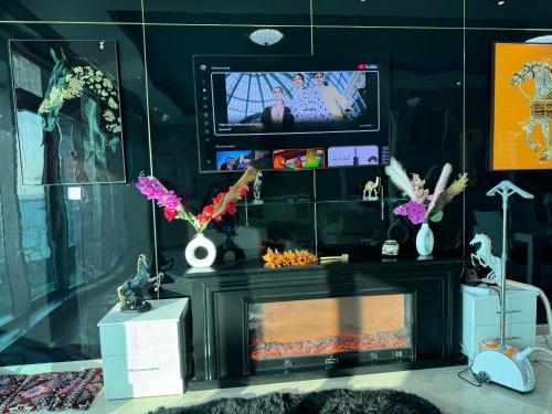 a living room with a fireplace and a tv at Sunset Beach View Holiday Homes in Ajman 