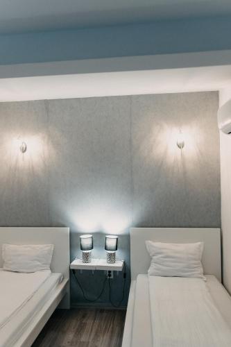 a room with two beds and a table with two lamps at Palma Vendégház in Szeged