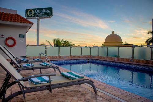 a swimming pool with a chair next to a building at Quality Inn Mazatlan in Mazatlán