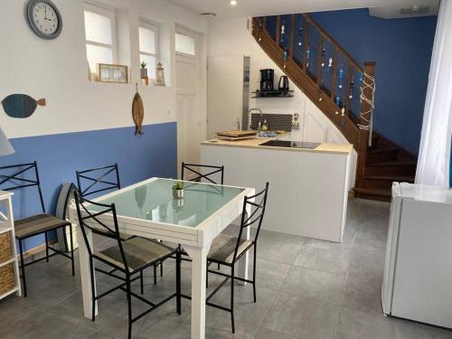 a kitchen with a table and chairs and a staircase at La clairière Merlimont in Merlimont