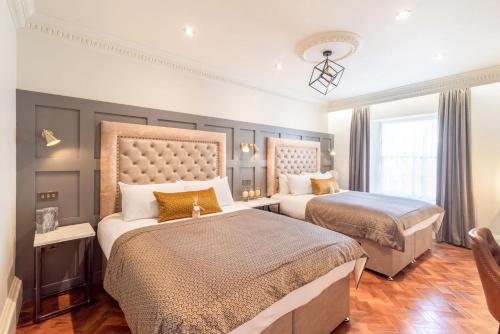 a bedroom with two beds and a large window at King Street Aparthotel in Stirling
