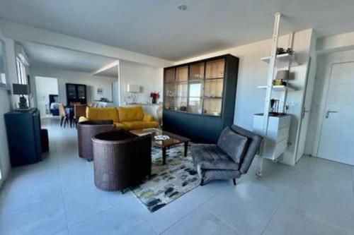 un salon avec un canapé et une table dans l'établissement Le Panoramique vue mer, à Dunkerque