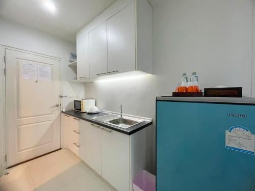 a small kitchen with a sink and a refrigerator at Baan Pattaya by Sabai in Pattaya Central