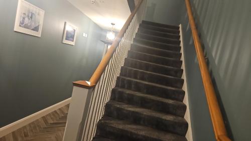 a stairway with a wooden hand rail and a stair case at The Manor Guest Accommodation Dungiven in Dungiven