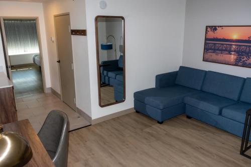 a living room with a blue couch and a mirror at La Quinta by Wyndham Dallas Mesquite in Mesquite