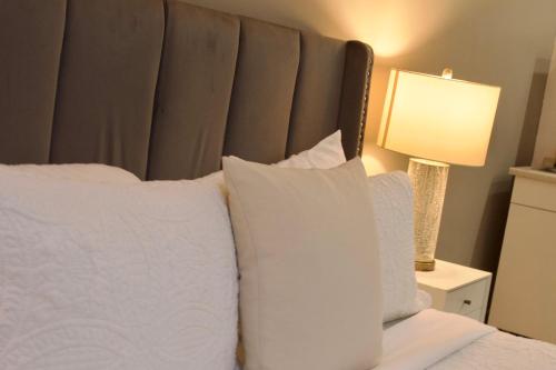 a bedroom with a bed with white pillows and a lamp at Couple's getaway studio in San Juan