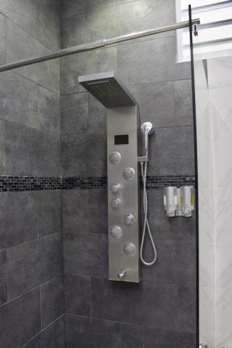 a shower with a shower head in a bathroom at Couple's getaway studio in San Juan
