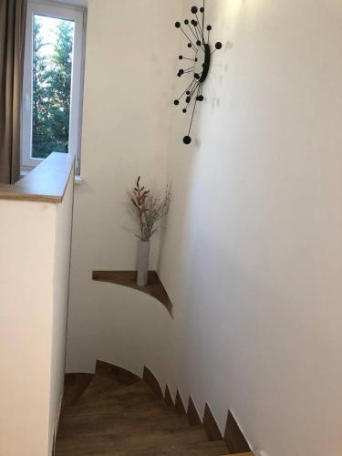 a stairway with a clock and a vase on a wall at Gavriel Boutique Residence Wellness Spa in Szada
