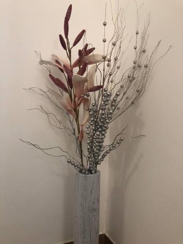 a vase with flowers and branches in a room at Gavriel Boutique Residence Wellness Spa in Szada