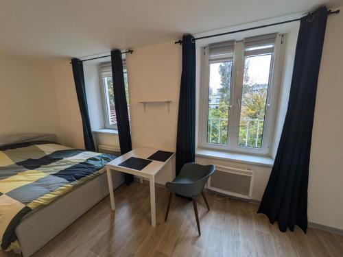 une chambre avec un lit, un bureau et une fenêtre dans l'établissement Appartement Studio, à Mulhouse