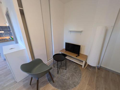 un petit salon avec une table et une télévision dans l'établissement Appartement Studio, à Mulhouse