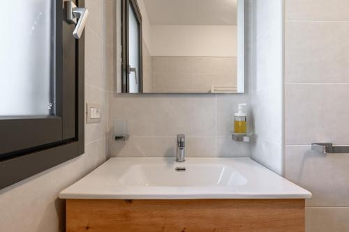 フィウミチーノにあるTiber Terrace Retreat - Free Parking, Wi-Fi & Netflixの白い洗面台と鏡のあるバスルーム