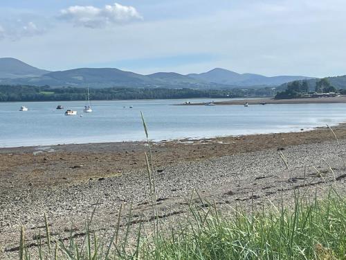 a beach with boats in a body of water at 2,Tros yr Afon in Beaumaris