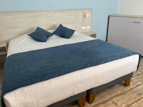 a large bed with blue pillows on top of it at Hotel Mareblu Iquique in Iquique