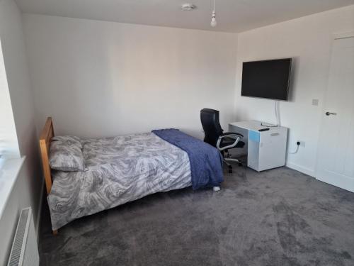 a bedroom with a bed and a desk and a television at Stratford Way House in Northfleet