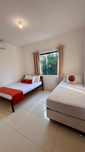 a bedroom with two beds and a window at Vila Verde in Palmeiras