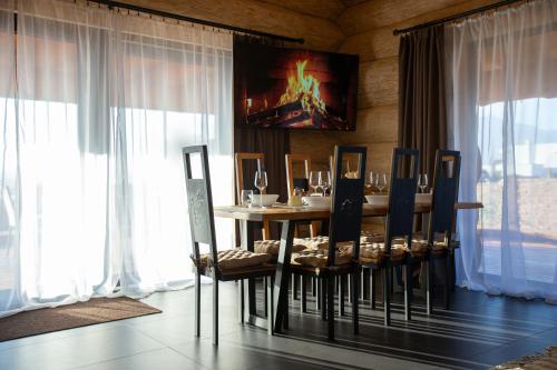 a dining room with a table and chairs and windows at Amia Chalet in Veľká Lomnica