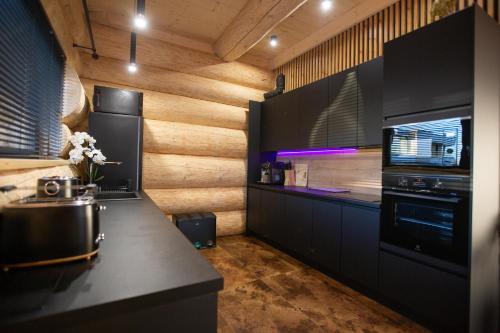 a kitchen with wooden walls and a counter top at Amia Chalet in Veľká Lomnica