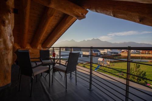 a balcony with a table and chairs and a view at Amia Chalet in Veľká Lomnica