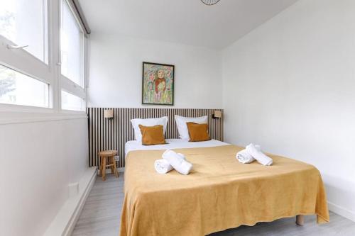 une chambre avec un lit avec deux serviettes dessus dans l'établissement Saint Fargeau Gambetta IV Lovely Apartment 4P 1BR, à Paris