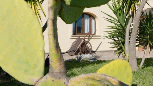 a statue of a frog sitting in the grass next to a building at Delle Rose, Hotel & Horse Riding in Torre Vado