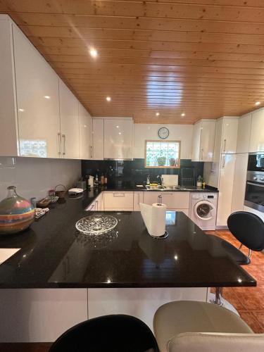 a kitchen with white cabinets and a black counter top at Casa do Vale - Seixas in Caminha
