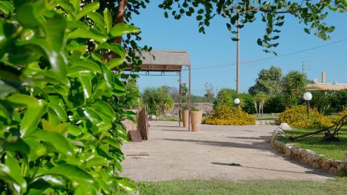 a walkway in a park with a pavilion at Delle Rose, Hotel & Horse Riding in Torre Vado