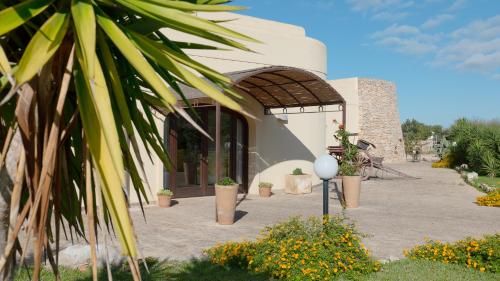 a building with a courtyard with potted plants on it at Delle Rose, Hotel & Horse Riding in Torre Vado