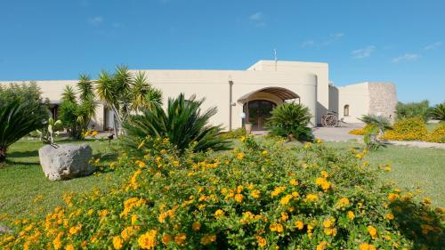 a building with a field of flowers in front of it at Delle Rose, Hotel & Horse Riding in Torre Vado