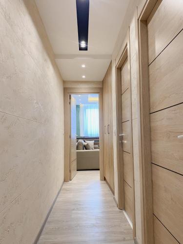 a hallway with wooden doors and a room with a couch at MB Apartmani Kopaonik in Kopaonik