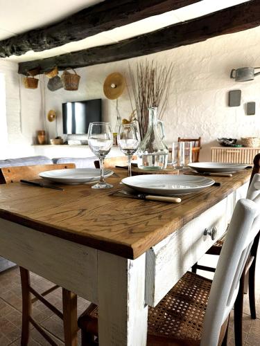 - une table en bois avec des verres à vin et des assiettes dans l'établissement La Casa aux Pommiers, à Guilliers