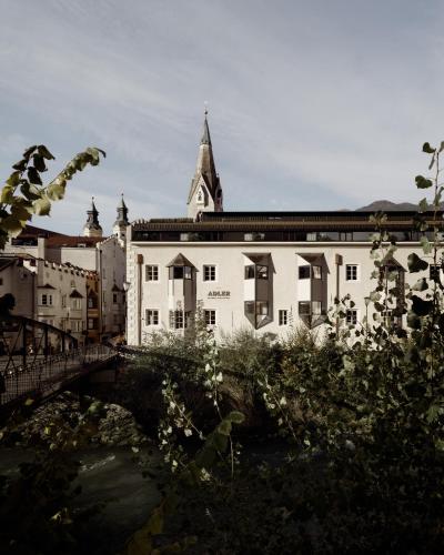a large white building with a tower on top of it at ADLER Historic Guesthouse in Bressanone