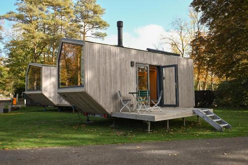 a tiny house is sitting on the grass at Tiny House Pioneer 2 - Green Tiny Spot Friesland in Schortens