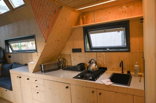 a kitchen with a stove in a tiny house at Tiny House Pioneer 2 - Green Tiny Spot Friesland in Schortens