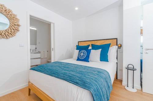 a bedroom with a large bed with blue pillows at Varanda Azul - Lookout Loft (City Centre) in Ponta Delgada