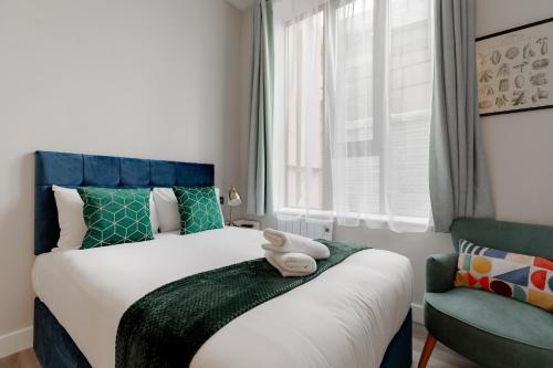 een slaapkamer met een bed met een teddybeer erop bij Hyde Park Studios in Londen