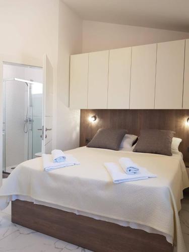 a bedroom with a large bed with white cabinets at Apartments Sun Dance 2 with heated Pool in Novalja