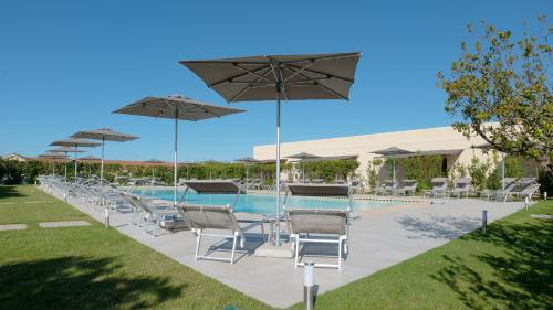 a group of chairs and umbrellas next to a pool at Delle Rose, Hotel & Horse Riding in Torre Vado