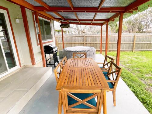 a wooden table and chairs on a patio at Luxury 4BR Oasis with Pool, Hot Tub & Game Room! in Cedar Park