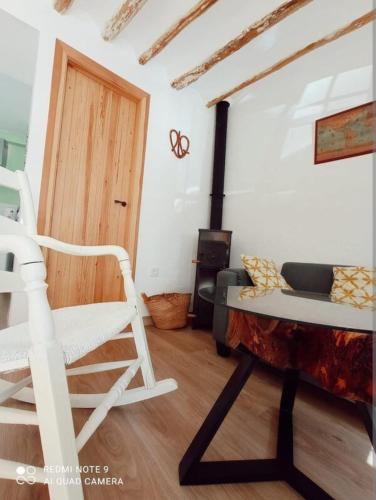a living room with a white chair and a couch at La Casita Tipica in Zuheros