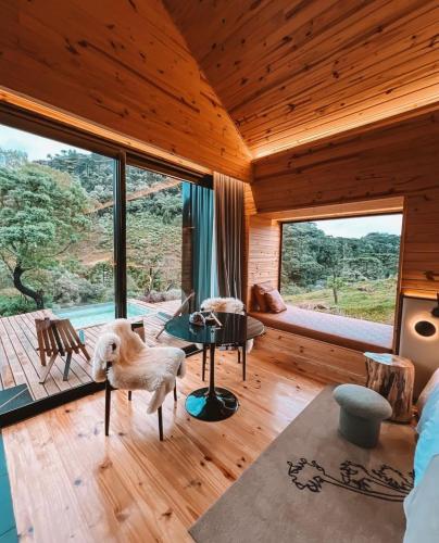 a living room with wooden ceilings and large windows at Vale Sagrado in Urubici