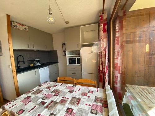 - une cuisine avec une table et une couette dans l'établissement Appartement confortable 4 pers., proche pistes et commerces, parking, balcon Sud-Ouest, animaux admis - FR-1-733-91, à Crest-Voland