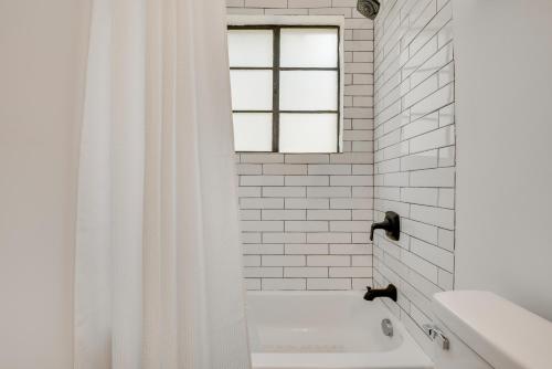 a white bathroom with a shower curtain and a tub at Private Porch! Cozy East ATL Stay Near World Cup in Atlanta