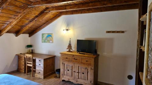 - une chambre avec un lit et une télévision sur une commode en bois dans l'établissement Chambres d'hôte des 3 Marches, à Lamoura