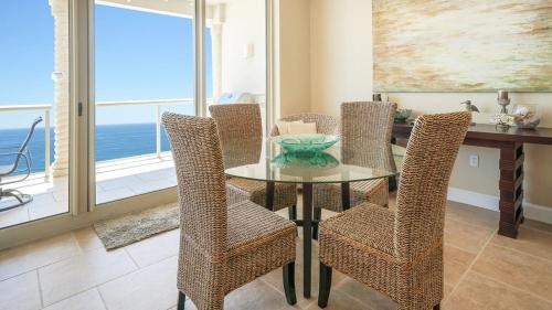 a dining room with a glass table and chairs at Beach Club Gulf Front 3B Condo - 1604 in Pensacola Beach