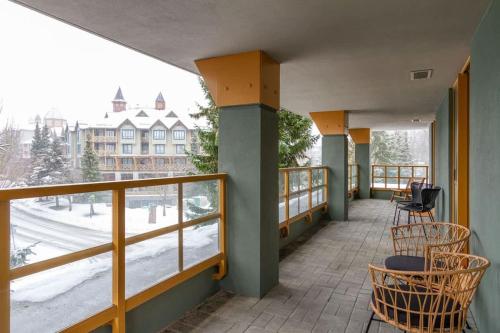 a balcony with chairs and a view of a street at Renovated 2Bed-2Bath in Village with Pool, Hot Tub, and Sauna in Whistler