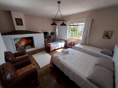a bedroom with two beds and a fireplace at Hotel Dom Paulo in Lapa