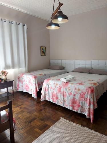a bedroom with two beds and a table at Hotel Dom Paulo in Lapa