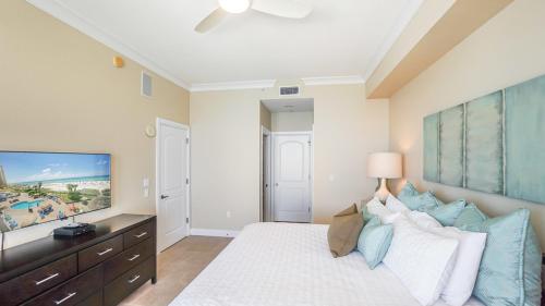 a bedroom with a large bed and a flat screen tv at Beach Club Gulf Front 3B Condo - 1604 in Pensacola Beach